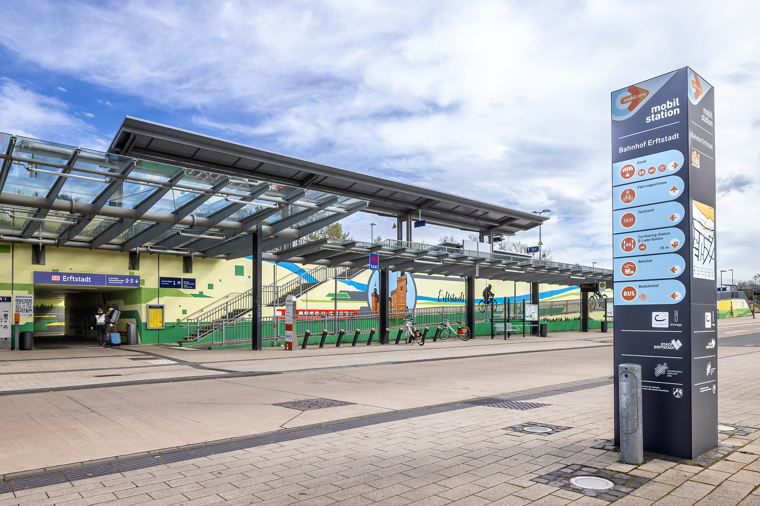 Die Station Erftstadt im Stadtteil Liblar von außen mit einer Mobilstations-Steele im Vordergrund.