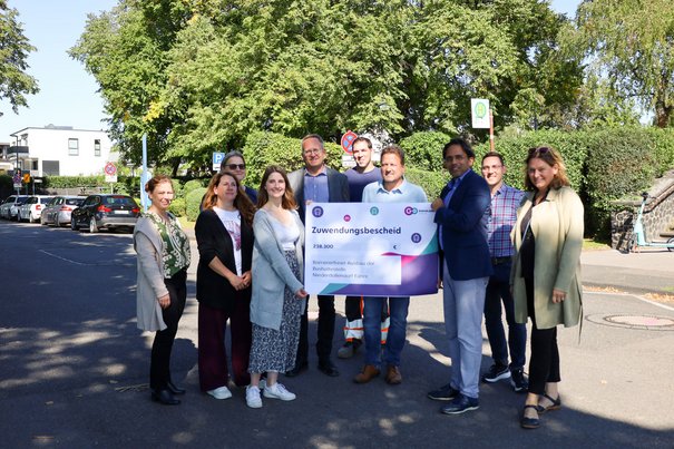 Die Stadt Königswinter freut sich zusammen mit Vertreterinnen und Vertretern von go.Rheinland, der Bezirksregierung Köln und der Baufirma Wurzel über die Förderungen und den Start der Maßnahmen an der Rheinuferstraße.